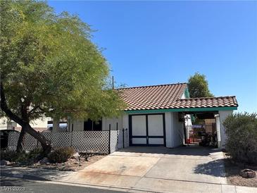 Charming single-story home with a lovely red-tiled roof, mature tree, and an inviting carport at 1731 Paloma Ave, Laughlin, NV 89029