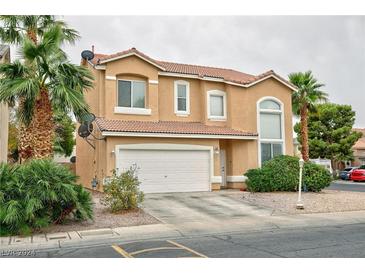 Charming two-story home featuring a terracotta-tiled roof, two-car garage, and lush landscaping with mature palm trees at 6007 Turtle River Ave, Las Vegas, NV 89156