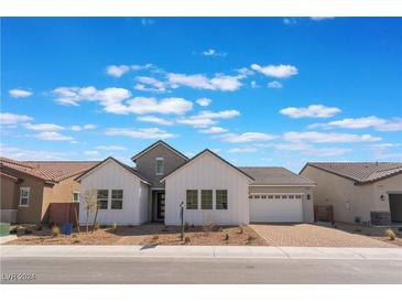 Charming home featuring a brick driveway, three gables, and a two-car garage, all under a bright, partly cloudy sky at 7132 Silver Palace St, Las Vegas, NV 89131