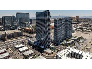 Wide aerial view of a modern high rise building with a mix of urban and suburban landscape under a bright blue sky at 4471 Dean Martin Dr # 2205, Las Vegas, NV 89103
