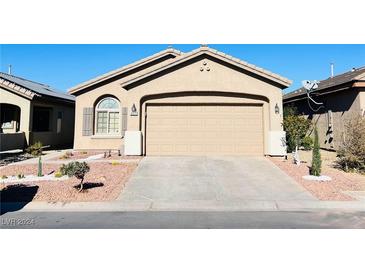 One-story house with tan exterior, two-car garage, and landscaped front yard at 6072 Corbin Ave, Las Vegas, NV 89122