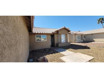 Beige single story home with well manicured rock landscaping, concrete walkway, and tile roof at 3505 Benson Ln, North Las Vegas, NV 89032