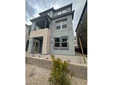 Modern two-story home with stone accents and a balcony at 1448 Nocturnal Flight St, Las Vegas, NV 89138