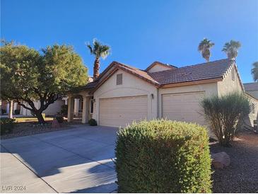 House exterior featuring a two-car garage and well-manicured landscaping at 841 Lusterview Ct, Las Vegas, NV 89123