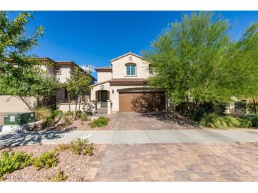 Inviting two-story home boasting a paver driveway, manicured landscaping, and a warm, neutral color palette at 829 N Water St, Henderson, NV 89011