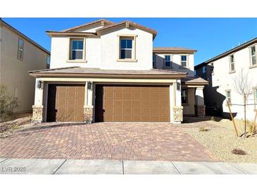 Two-story house with brown double-door garage and brick driveway at 9886 Belikove Manor Ave, Las Vegas, NV 89178