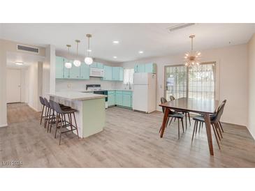 Open kitchen featuring light blue cabinetry, a breakfast bar, and modern appliances at 2212 Kirk Ave, Las Vegas, NV 89101