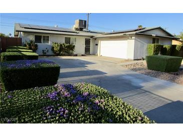 Single-story house with a two-car garage, landscaping, and solar panels at 5900 Gordon Ave, Las Vegas, NV 89108