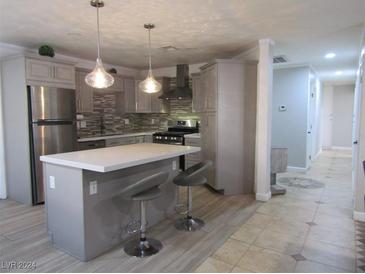 Modern kitchen with island, stainless steel appliances, and light gray cabinets at 5900 Gordon Ave, Las Vegas, NV 89108