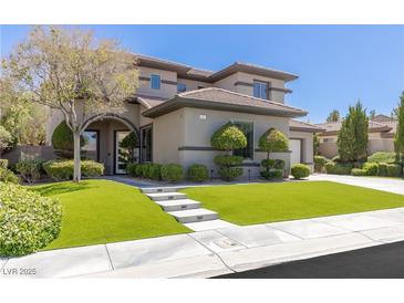 Stunning two-story home features a lush green lawn, manicured landscaping, and a modern architectural design at 17 Winding Rd, Henderson, NV 89052