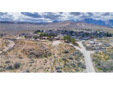 Scenic aerial view of a small desert town surrounded by mountains under a cloudy sky at 16 Cerrito St, Blue Diamond, NV 89004