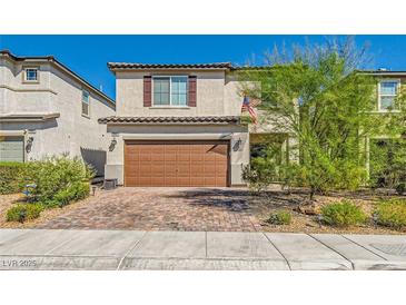 Charming two-story home featuring a brick driveway, two-car garage, and lovely landscaping at 6322 Highledge St, North Las Vegas, NV 89081