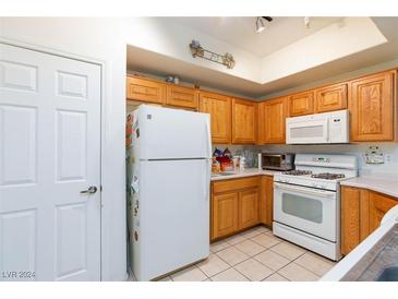 Bright kitchen with oak cabinets, white appliances, and ample counter space at 5855 Valley Dr # 1028, North Las Vegas, NV 89031