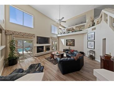 Spacious living room with high ceilings, fireplace, and views of the pool at 8713 W Gilmore Ave, Las Vegas, NV 89129