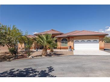 Charming single-story house with a large driveway and a well-manicured front yard with mature landscaping at 1830 E Fuchsia St, Pahrump, NV 89048