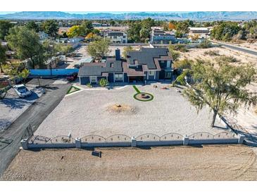 Spacious property with modern home, gravel yard, solar panels, mountain views, and decorative front turf at 7135 Polaris Ave, Las Vegas, NV 89118