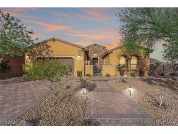 Inviting single-story home featuring a paved walkway and beautiful desert landscaping at 45 Moltrasio Ln, Henderson, NV 89011