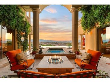 Stunning outdoor patio with a fire pit, spa, city view, and comfortable seating, perfect for relaxation at 1309 Imperia Dr, Henderson, NV 89052