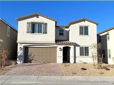 Two-story house with a brown garage door and light-colored brick driveway at 9902 Belikove Manor Ave, Las Vegas, NV 89178