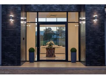 Inviting home entrance with large glass windows and doors, providing ample natural light and views at 73 Princeville Ln, Las Vegas, NV 89113