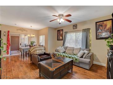 Bright living room features hardwood floors, comfy seating, and access to the dining area at 9580 W Reno Ave # 238, Las Vegas, NV 89148