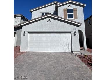 Two-story house with a white garage door and gray stone driveway at 9096 Vesey Ave, Las Vegas, NV 89148