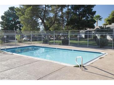 Inviting community swimming pool with surrounding fence and trees at 261 N Lamb Blvd # B, Las Vegas, NV 89110