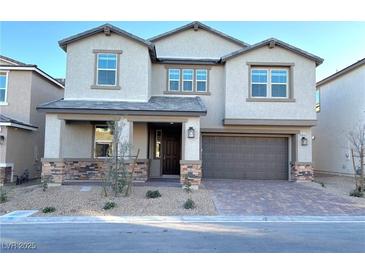 Two-story house with stone accents and a brown garage door at 9813 Belikove Manor Ave, Las Vegas, NV 89178