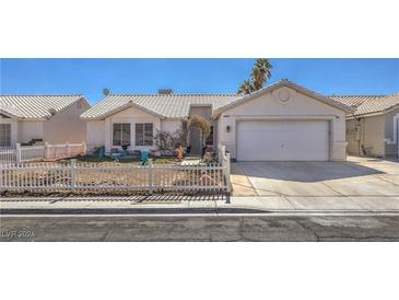 Charming single-story home featuring a white picket fence, desert landscaping, and a two-car garage at 4357 Valley Regal Way, North Las Vegas, NV 89032