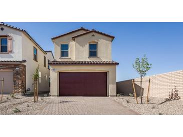 Two-story home with a brick driveway leading to a two-car garage, complemented by neutral color palette at 657 N Water St, Henderson, NV 89015
