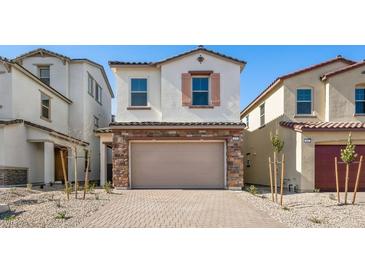 Inviting home featuring a stone-accented two-car garage and neutral stucco exterior, framed by desert landscaping at 655 N Water St, Henderson, NV 89015