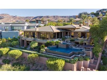 Stunning two-story home with stone accents, a pristine pool, and lush landscaping at 1492 Macdonald Ranch Dr, Henderson, NV 89012