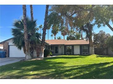 Charming single-story home with well-maintained lawn and mature trees providing ample shade at 3909 Woodhill Ave, Las Vegas, NV 89121