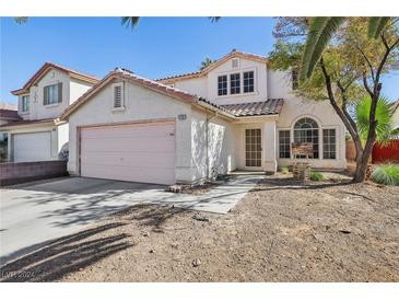 Two-story house with pink garage door, landscaping, and driveway at 1712 Orchard Valley Dr, Las Vegas, NV 89142