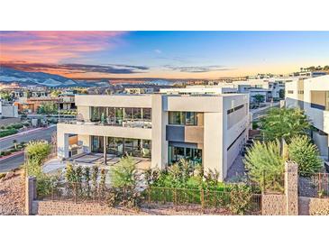 Modern two-story home featuring a balcony, large windows, and a beautifully landscaped yard, nestled within a vibrant community at 28 Rainbow Point Pl, Henderson, NV 89011
