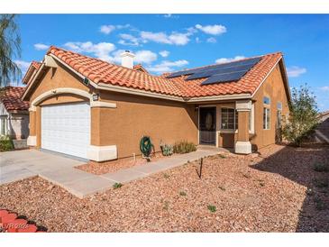 Tan one-story house with solar panels, tile roof, and a white garage door at 6370 Canyon Vista Ct, Las Vegas, NV 89156