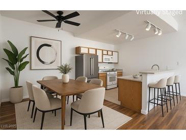 Bright dining area featuring a modern ceiling fan and seating for six adjacent to the kitchen with stainless steel appliances at 4960 Harrison Dr # 214, Las Vegas, NV 89120