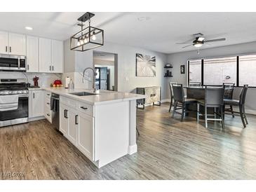 Open concept kitchen and dining area, featuring modern appliances and stylish island at 2801 Willow Wind Ct, Las Vegas, NV 89117