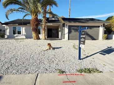 Charming single-story home with desert landscaping, palm trees, and a two-car garage at 2606 Vegas Valley Dr, Las Vegas, NV 89121