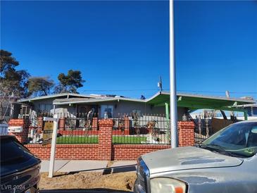 Ranch style home with brick facade, landscaped lawn, and carport at 1708 Weeping Willow Ln, Las Vegas, NV 89104