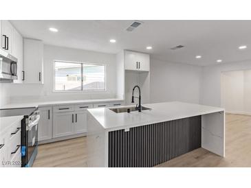 Modern kitchen with island, stainless steel appliances, and white cabinetry at 2368 Winterwood Blvd, Las Vegas, NV 89142