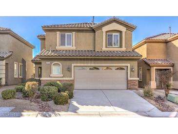 Two-story house with tan exterior, large garage, and landscaping at 315 Foster Springs Rd, Las Vegas, NV 89148