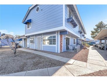 Light blue exterior of a condo building with parking and walkway at 5330 Duralite St # 102, Las Vegas, NV 89122