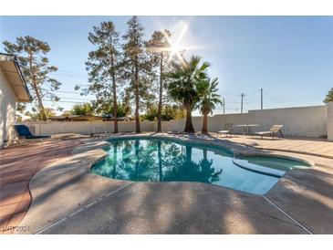 Inviting kidney-shaped pool with patio and lounge chairs at 5905 Paseo Montana, Las Vegas, NV 89108