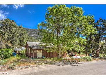 Mountain cabin exterior with large tree and paved road at 3968 Mont Blanc Way, Las Vegas, NV 89124