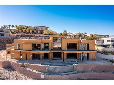 Unfinished modern home with a pool under construction, surrounded by desert landscape and mountain views at 1487 Reims Dr, Henderson, NV 89012