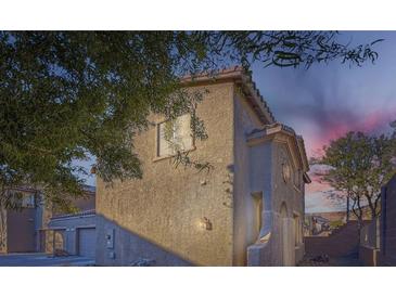 Tan two-story house with a landscaped yard, attached garage, and a walkway at 9790 Overlook Ridge Ave, Las Vegas, NV 89148