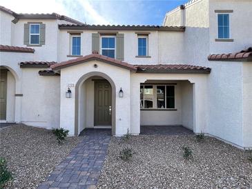 Charming townhome with stucco exterior, covered porch, and desert landscaping at 2723 Luzzi Walk, Henderson, NV 89044