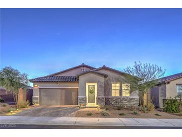 Charming single-story home featuring a two-car garage, stone accents, and a well-manicured front yard at 617 Sylvan St, Henderson, NV 89002