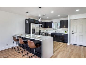 Modern kitchen with stainless steel appliances and a breakfast bar at 1693 Jupiter Ct # B, Las Vegas, NV 89119